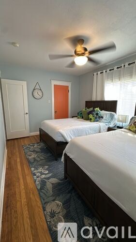 A bedroom with two beds and a ceiling fan.