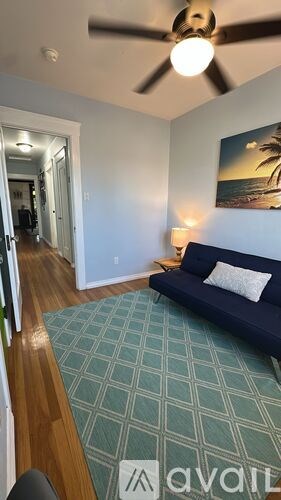 A living room with a couch and a painting on the wall.