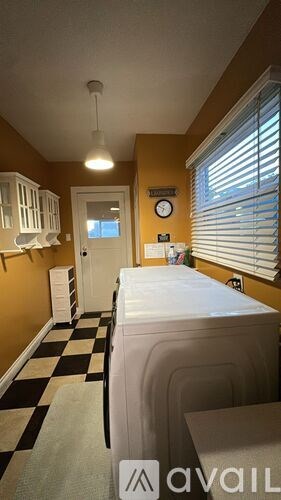A bedroom with a bed, dresser, and window with blinds.
