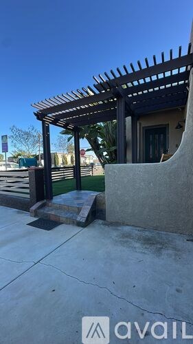 A patio area with a pergola and a bench.