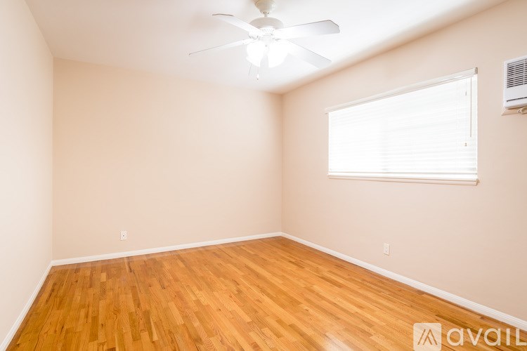 A room with wooden flooring and a ceiling fan.