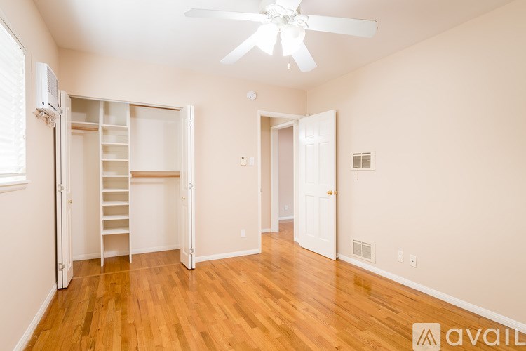 A room with a wooden floor and a ceiling fan.