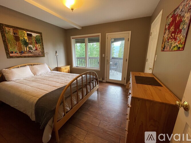 A bedroom with a large bed and a wooden dresser.