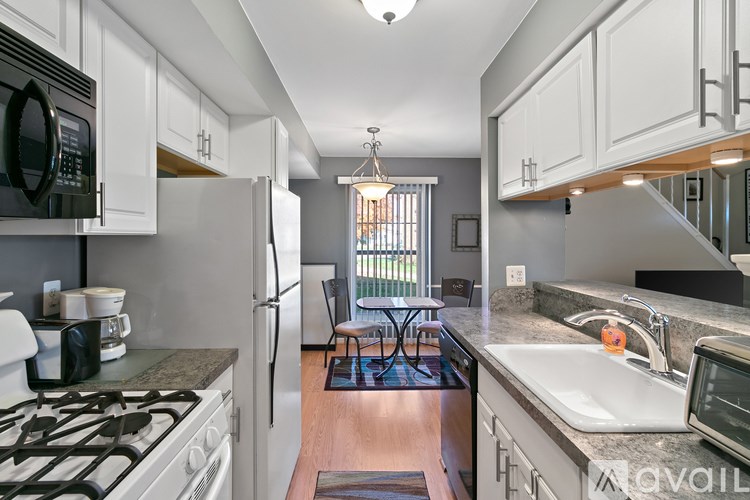 A kitchen with a black stove top oven and a white refrigerator.