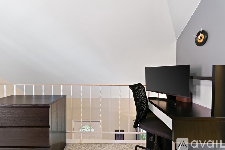 A black television sits on a wooden stand in a room with a white ceiling.