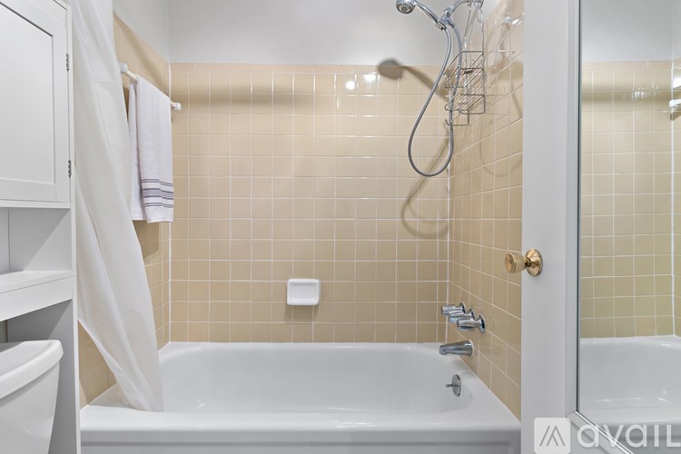 A white bathroom with a tub, sink, and shower.