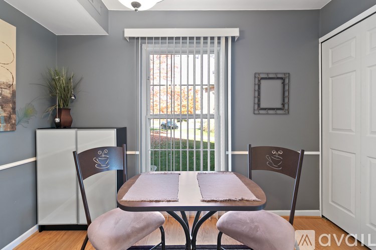 A dining room with a table and chairs.