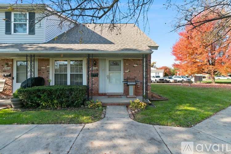 A house with a white door and a brick wall.