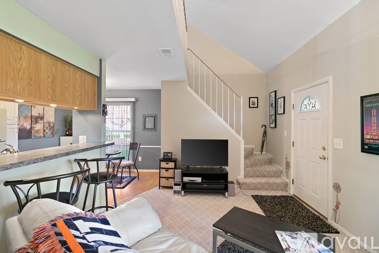 A living room with a couch, chairs, and a television.