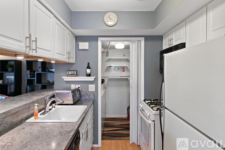 A kitchen with a white refrigerator and a sink.