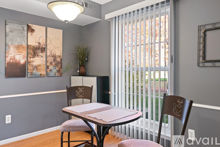 A dining room with a table and chairs.