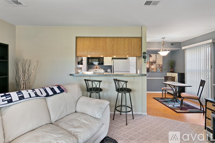 A living room with a white couch and a kitchen area in the background.