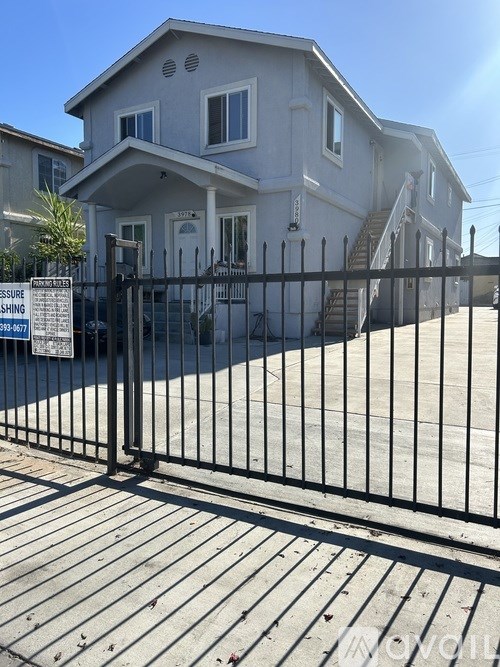 A house with a black fence and a sign that says "Pressure Washing" in front of it.