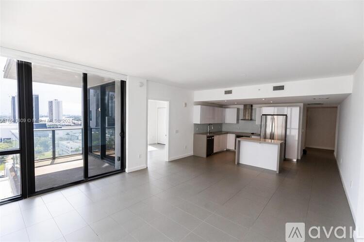 A spacious, well-lit living area with a kitchen and a view of the city.