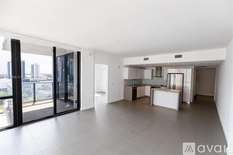 A spacious, well-lit living area with a kitchen and a view of the city.