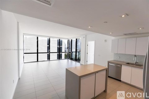 A modern kitchen with white cabinets and a central island.
