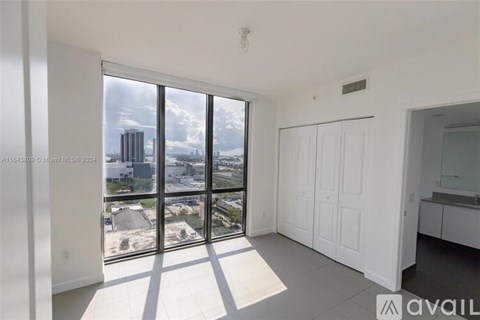 A spacious room with large windows overlooking a cityscape.