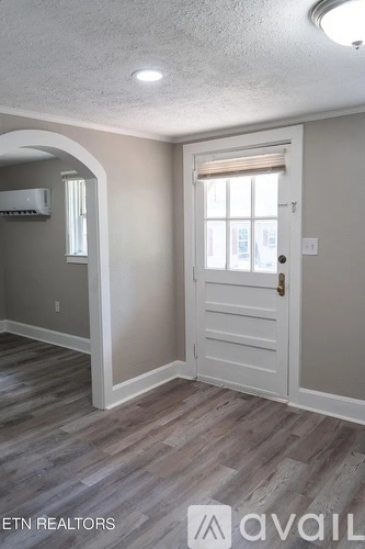 A room with a white door and a window with blinds.
