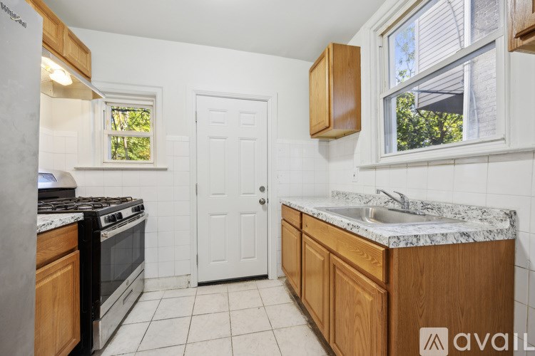 A kitchen with a white door, a black stove, and a wooden cabinet.