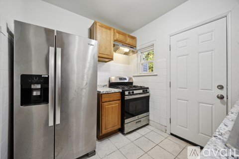 A kitchen with a stainless steel refrigerator and a stove top oven.