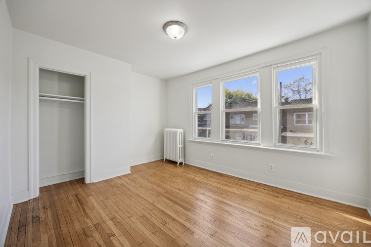 A room with wooden floors and a window showing a view of a building outside.