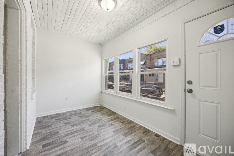 A room with a white door and a window showing a street view.