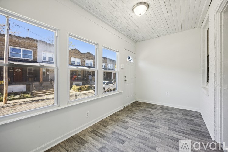 A room with a wooden floor and a window showing a street view.