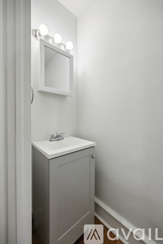 A white bathroom vanity with a mirror above it.