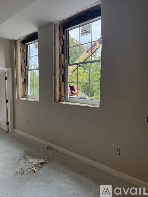 A room with two windows under construction.