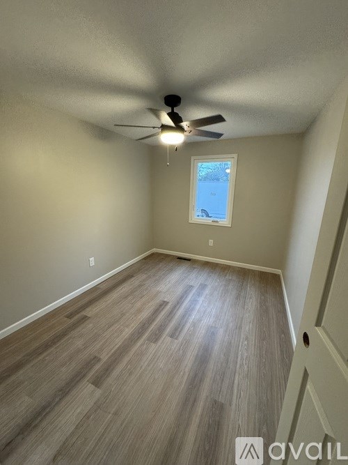 A room with a ceiling fan and a window.