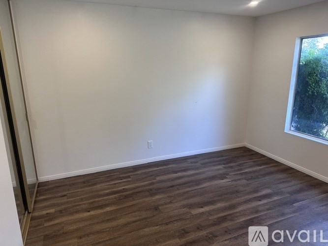 A room with wooden flooring and a window.