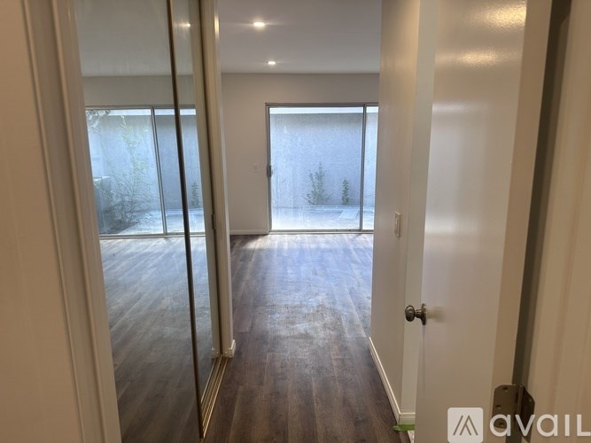 A room with a door and a window with a view of a snowy landscape.