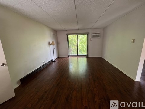 A room with wooden floors and a sliding glass door leading outside.