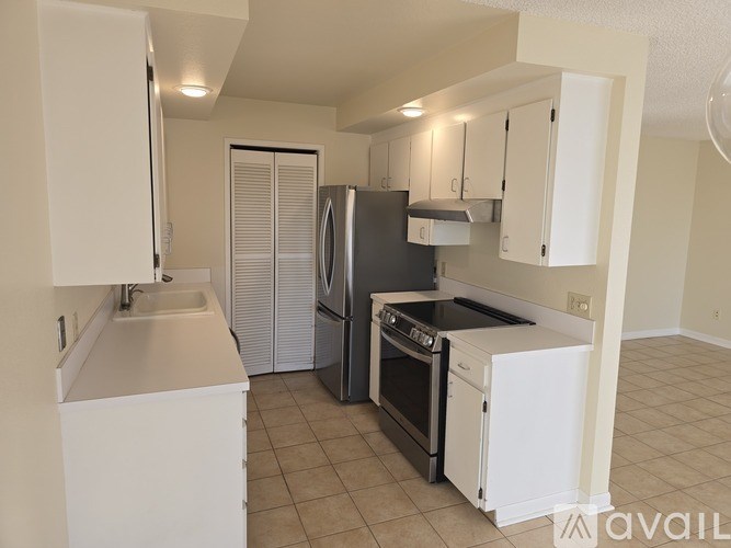 A kitchen with white cabinets and appliances.