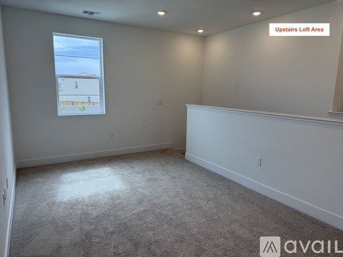 A room with a carpeted floor and a window showing a building outside.