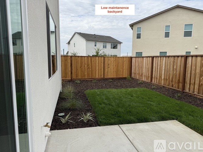 A backyard with a wooden fence and a small garden area.