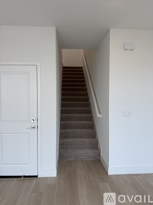 A staircase with a white door on the left side.