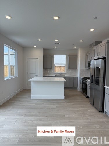 A spacious kitchen and family room with a large island and stainless steel appliances.