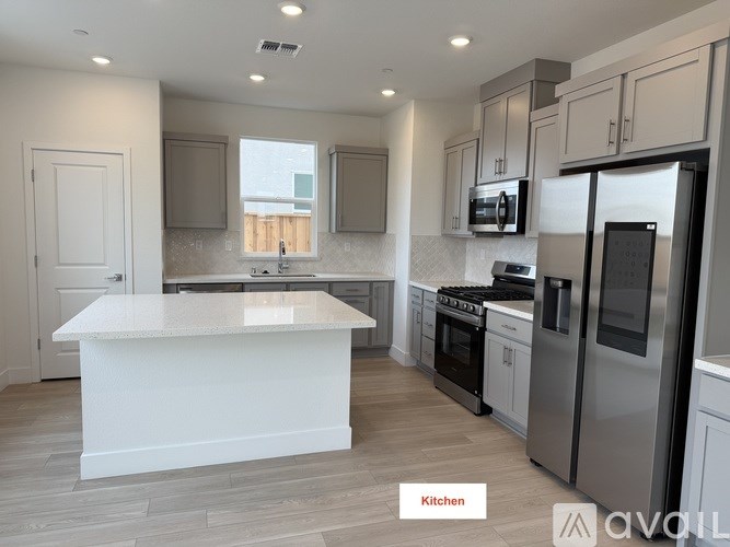 A modern kitchen with stainless steel appliances and a central island.