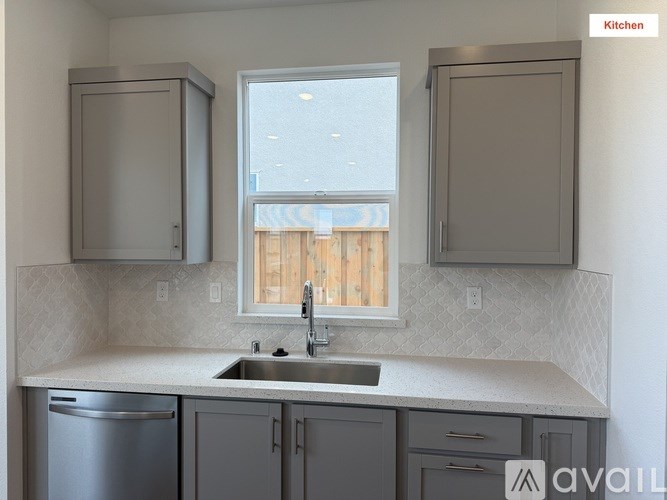 A kitchen with a sink, a window, and cabinets.