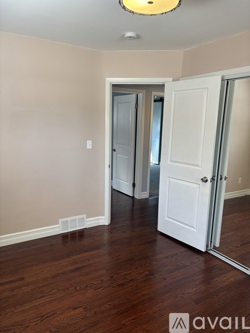 A room with a white door and a mirror on the wall.