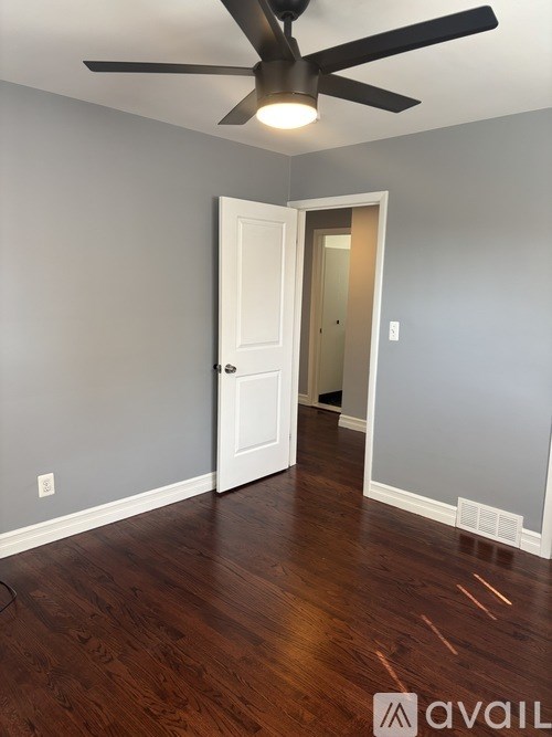 A room with a ceiling fan and a white door.