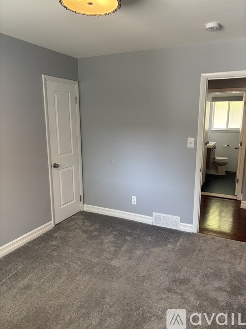 A room with a carpeted floor and a door.
