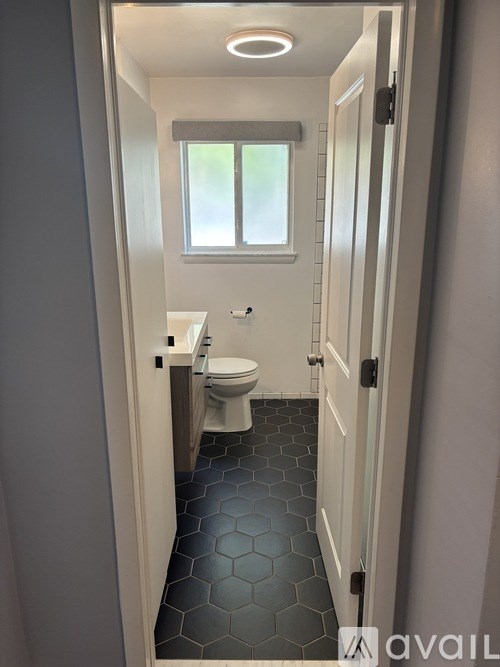 A bathroom with a toilet and a window.