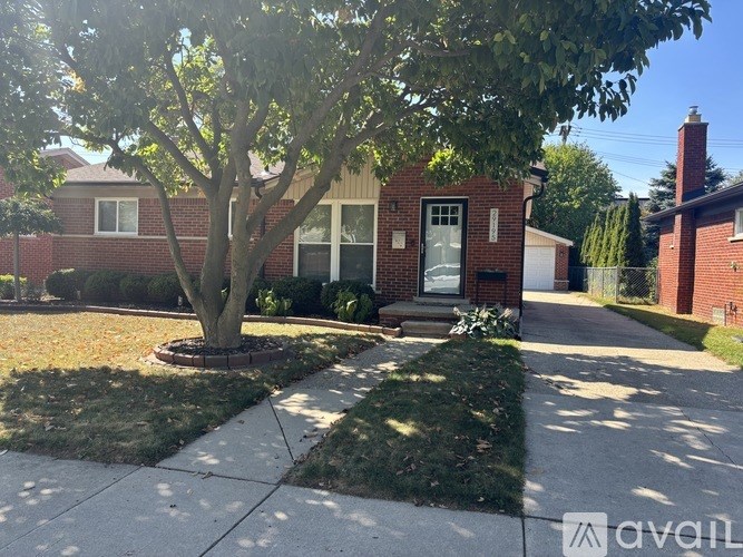 A tree in front of a house with a sign that says "available".