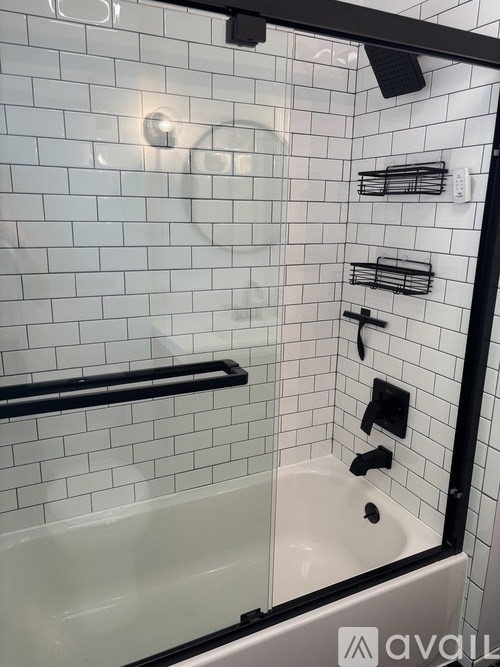 A white tiled bathroom with a black frame.
