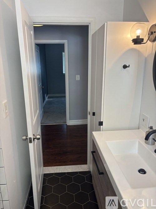 A bathroom with a white sink and a mirror.
