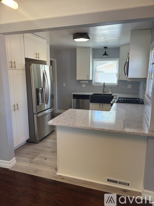 A kitchen with a white island and stainless steel appliances.