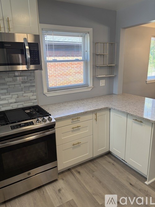 A kitchen with a stove, microwave, and cabinets.