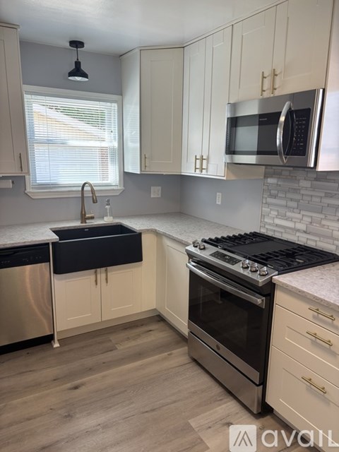 A kitchen with a stove top oven and a microwave above it.
